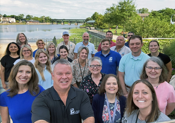 A group of City of St. Charles workers pose for a selfie taken by the mayor at City Hall, overlooking the river.