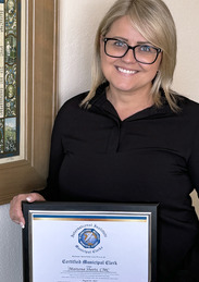 City's Deputy Clerk stands with certificate in front of the Constitution.