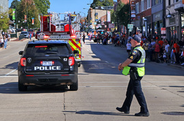 A police officer directs traffic at a stoplight on Main Street after the parade.