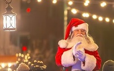 Santa Claus at night lighting the lights.