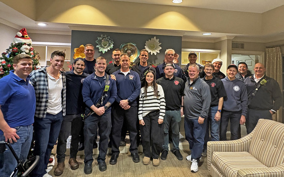 Firefighters pose for photo at senior living facility.