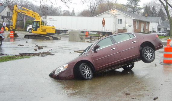 Car partially submerged in a swale on North 8th Avenue as floodwaters obscure the pavement edge, April 18, 2013
