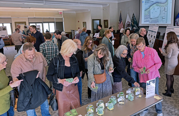 A group of people gather in front of a table for the Former Police Station Site workshop in April.