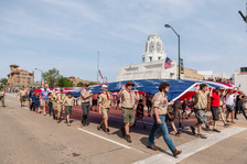 A group of scouts carries an American flag down Main Street in St. Charles.