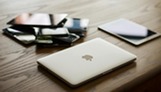 A computer and other discarded devices stacked on a table.