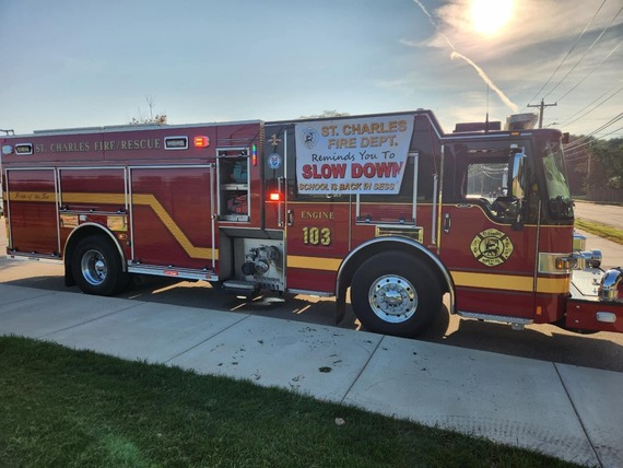 A fire truck has a "Slow Down" sign to remind motorists not to rush, as school as started and more cars and kids are on the streets.