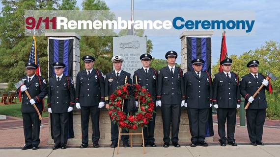 Firefighters pose in front of the Fire Department Memorial Monument