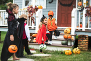 Trick-or-treaters visit a house in their costumes for Halloween.