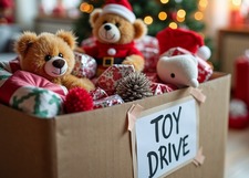A box of toys with a Christmas tree and presents in the background.