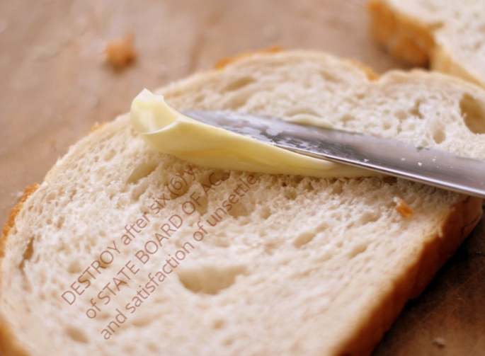 Photo of knife spreading butter on toast, with partially-obscured text reading 'DESTROY after six (6) yea...' and additional semi-obscured records retention instructions.
