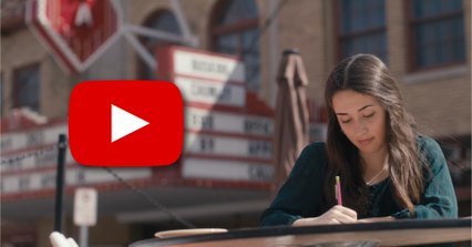 Photo of a girl writing at a table, red YouTube play button on photo