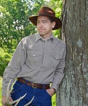 Joe Caudell leaning against a tree