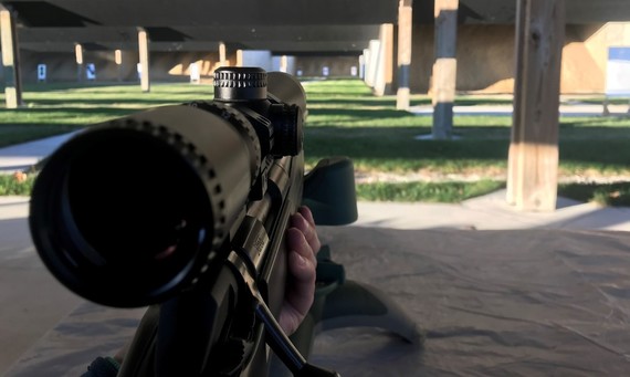 A scope on a rifle at a shooting range