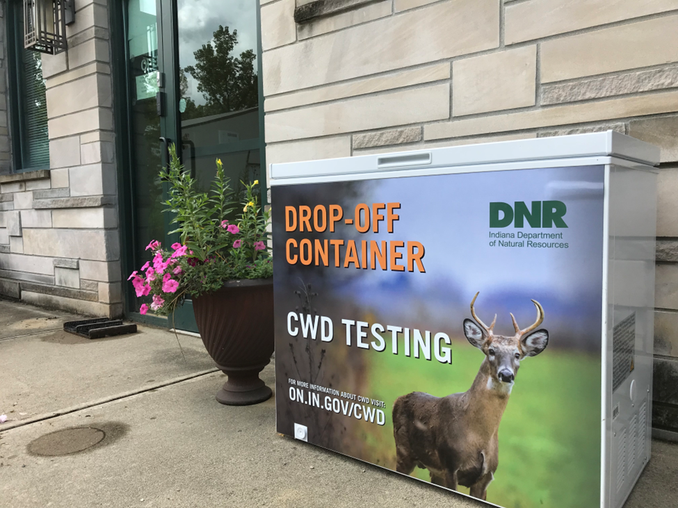A container labeled “Drop Off-Container: CWD Testing” with a photo of a deer on it.