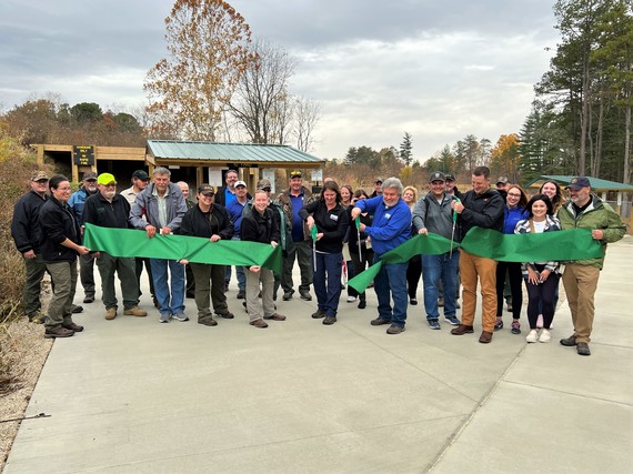 Sugar Ridge Fish & Wildlife Area staff members with DNR officials and partners cut a large green ribbon.