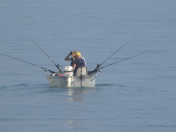 Two men fishing in a small boat.