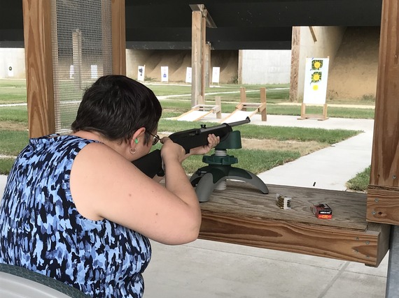 A woman shooting a firearm at a target.