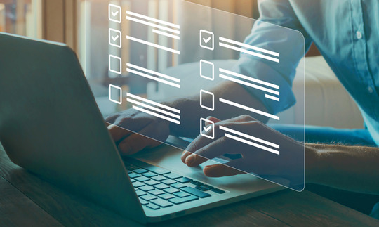 person typing on computer with digital overlay of checklists