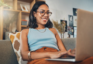 Woman sitting on couch using laptop