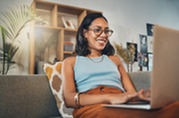 Woman sitting on couch using laptop