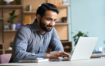 Man sitting at desk looking at laptop