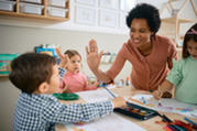 Child care provider high-fiving child