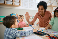 Child care provider high-fiving child