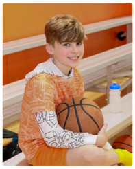 A boy sitting on a bench holding a basketball at John R. Dennis Wellness Center