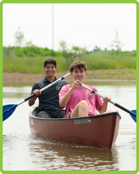 Two guys rowing on a canoe
