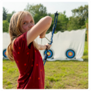 A girl aiming a bow and arrow at a target