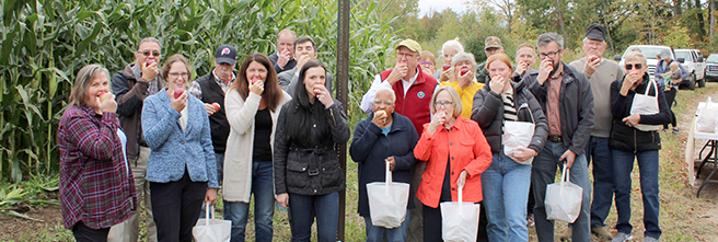 Image of Farm Preservation group eating apples at the same time