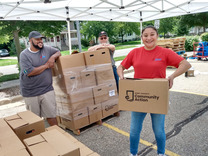 Image of volunteer holding a food box for Kent County Community Action