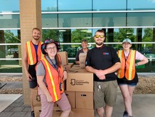 Image of five KCCA volunteers and staff around food distribution boxes