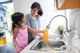 Image of mother and daughter at the kitchen faucet