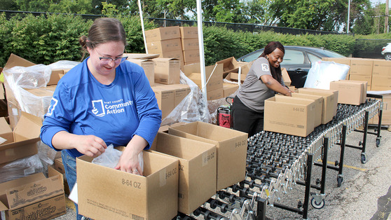 Image of two women packing boxes with food, for distribution