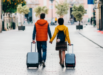 Image of two people walking with luggage