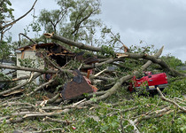 Image of a house and truck damages by fallen trees