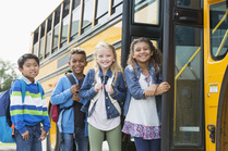 Image of kids in fron tof the school bus