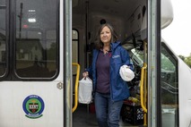 Image of a KCCA bus driver, walking out the bus doors