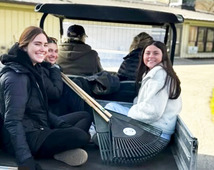 Image of parks volunteers in the back of a golf club with rakes