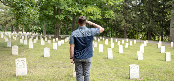 Veteran saluting in a military cemetary