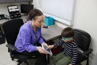 Pictured is a young boy participating in a hearing and vision screening at the KCHD.