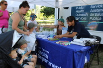  Picture of a KCHD employee interacting with a family at the event.