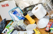 A Bunch of Supplies Recommended for an Emergency Supply Kit are Spread Across a Table