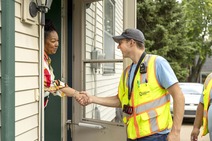 Image of a man shaking hands with a woman on her front steps