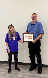 Greg VanderKooi Accepts the People's Champion Award from August's Winner, Christine Stewart