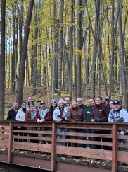A Group of Stewards, Volunteers, and Residents Stop and Post on a Bridge within Lepard Nature Preserve on a Crisp, Fall Day