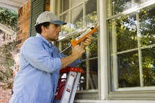 Man caulking a window