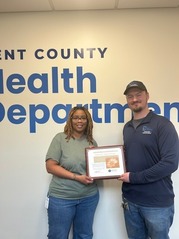 Last Month's People's Champion Award Recipient, Keitsha Barnett, Presents the Plaque o Mike Sacha