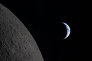 As the manned Orion spacecraft passes closely by the moon, Earth can be seen experiencing night and day in the distance